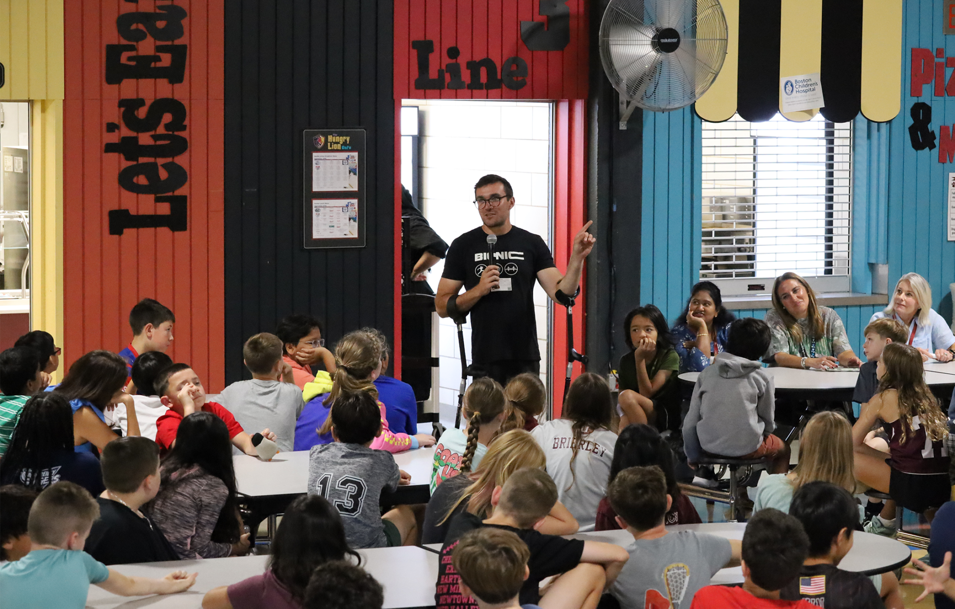Nico Calabria of Bionic Project speaks during an assembly for fifth graders in the cafeteria at Parker Middle School in Chelmsford.