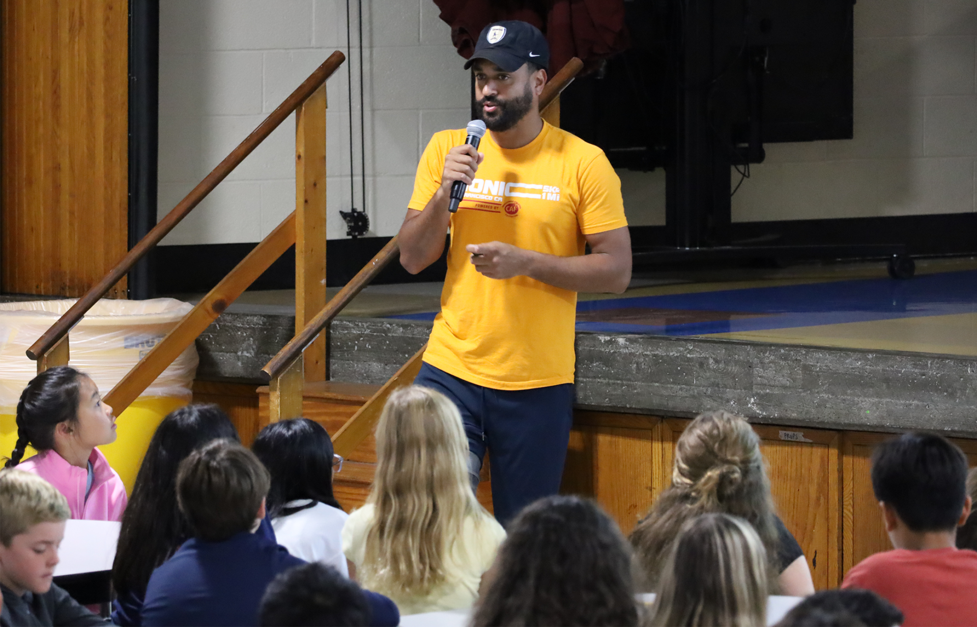 Jovan Booker of Bionic Project speaks during an assembly for fifth graders in the cafeteria at Parker Middle School in Chelmsford.